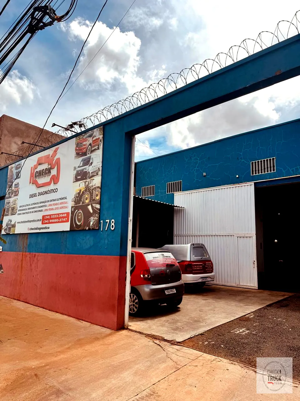 Frente da oficina da Check, com o banner de serviços na parede azul