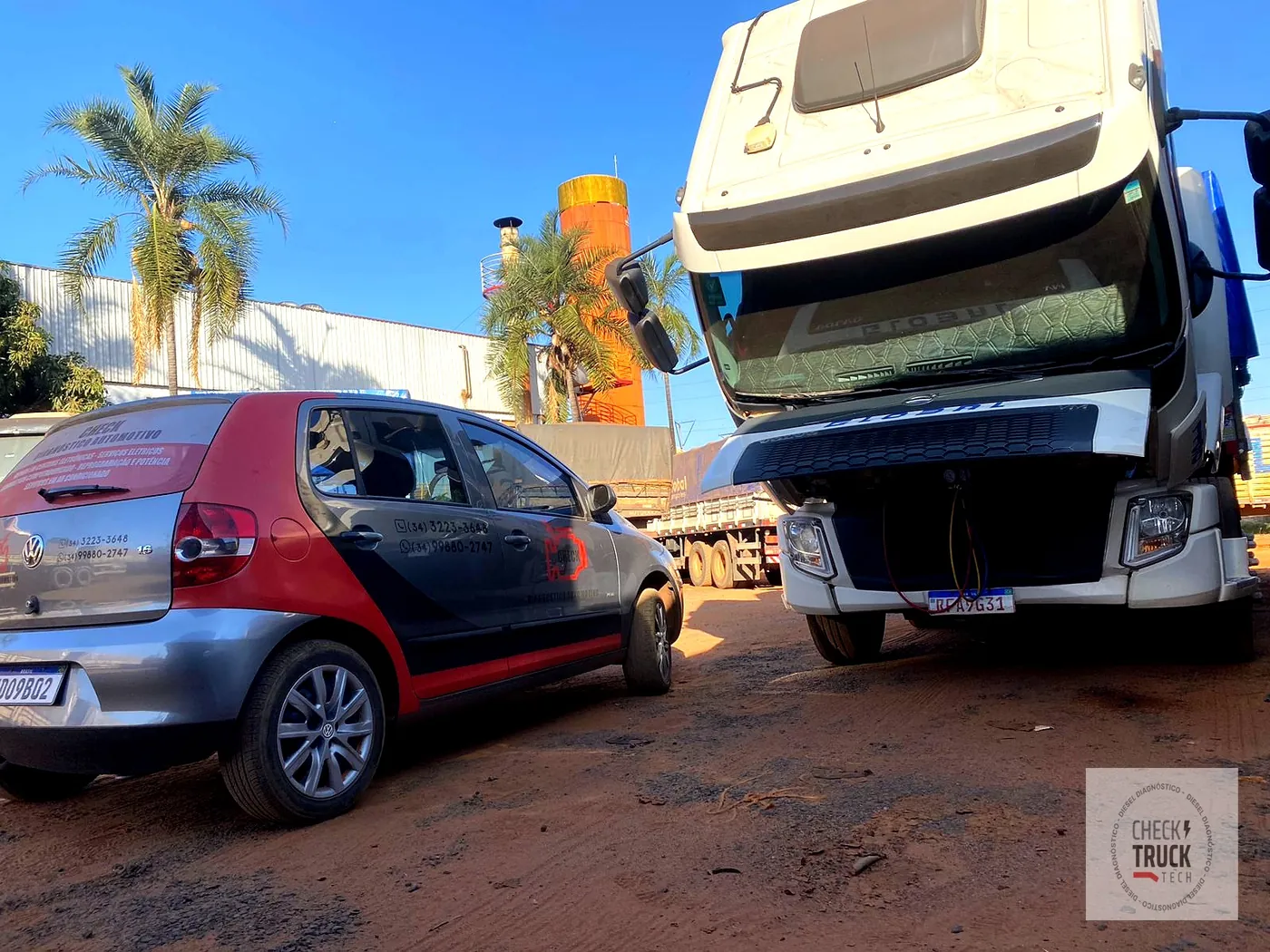 Caminhão basculante com a cabine levantada, em atendimento no pátio