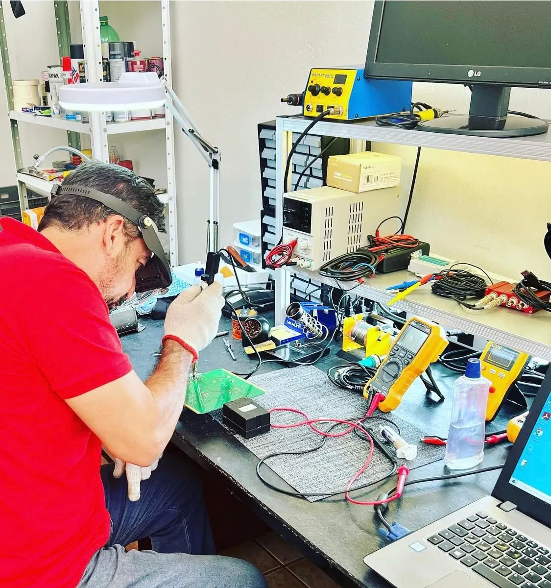 Técnico da Check com lupa de cabeça soldando uma placa na bancada