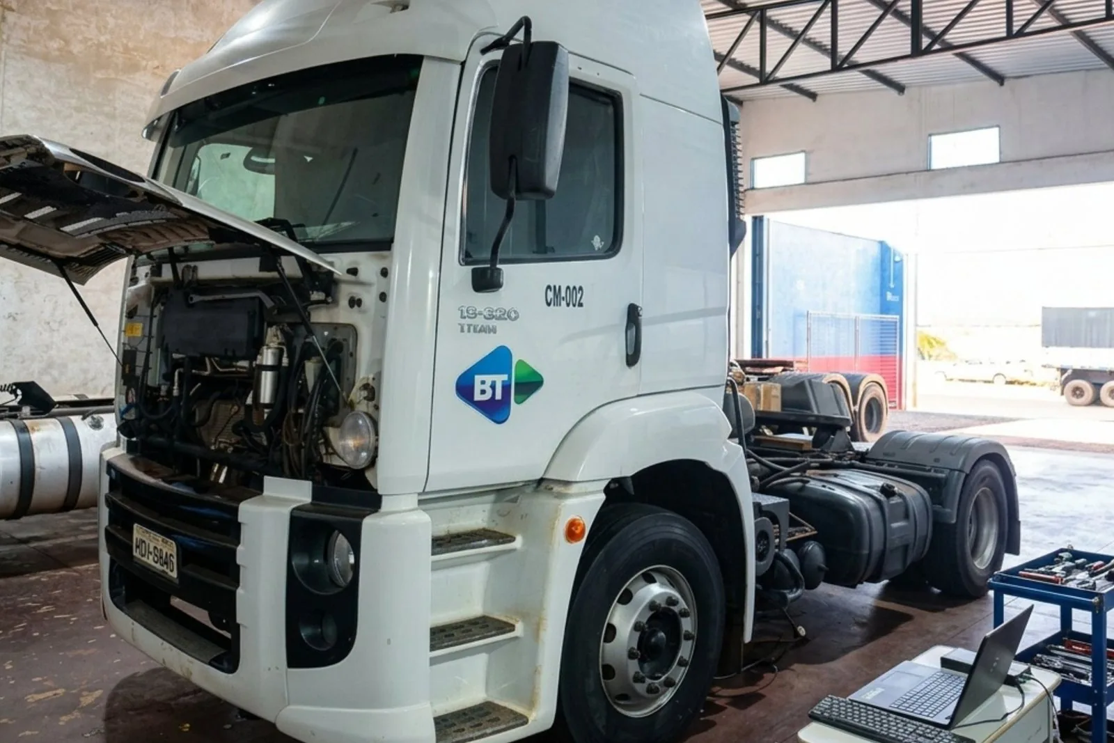 Caminhão Ford Cargo com o capô aberto na oficina da Check, notebook conectado para diagnóstico